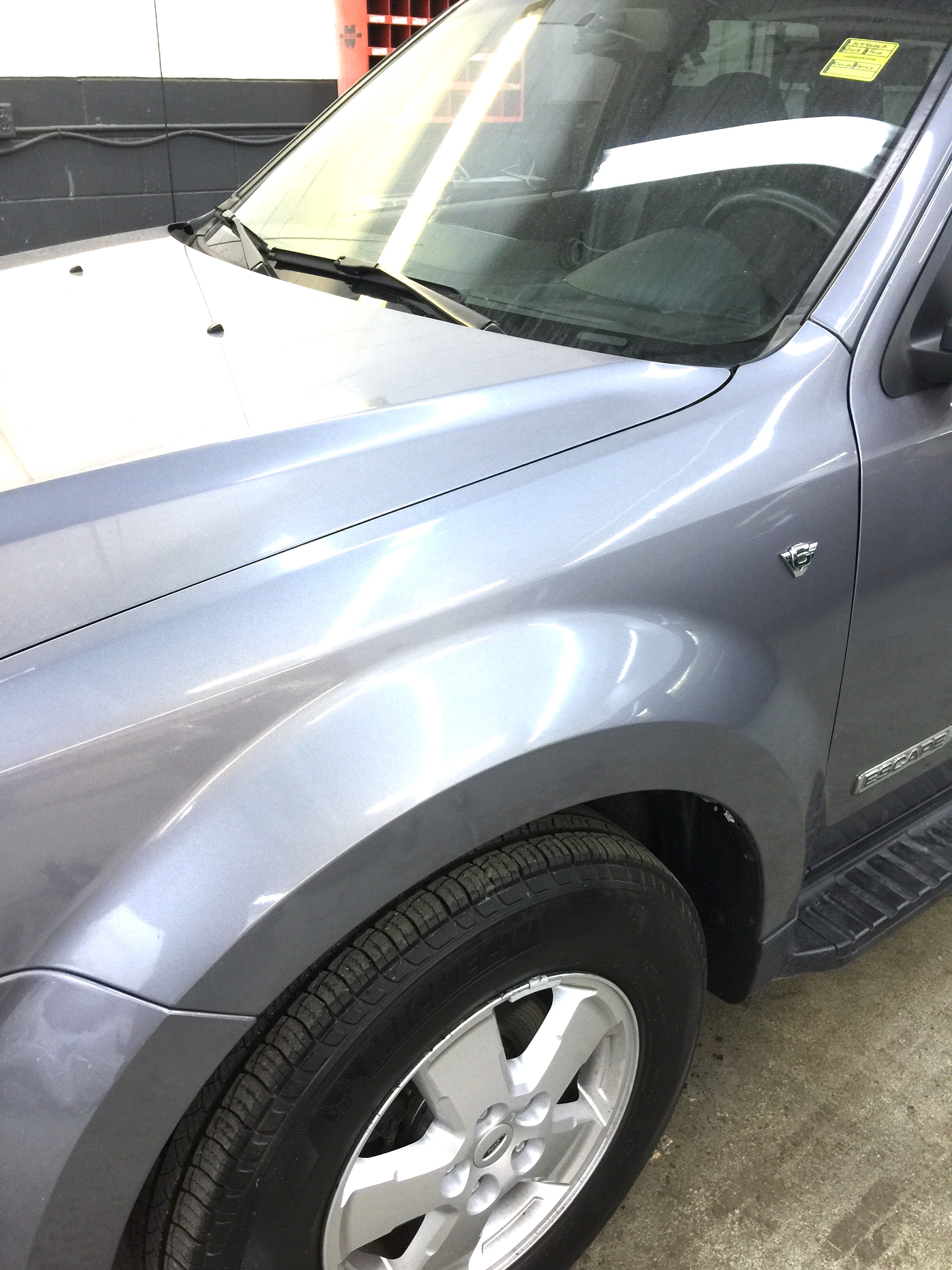 Before front fender crease repair on silver SUV